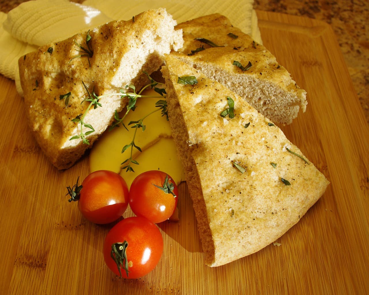 Focaccia with herbs, cut into wedges, with cherry tomatoes